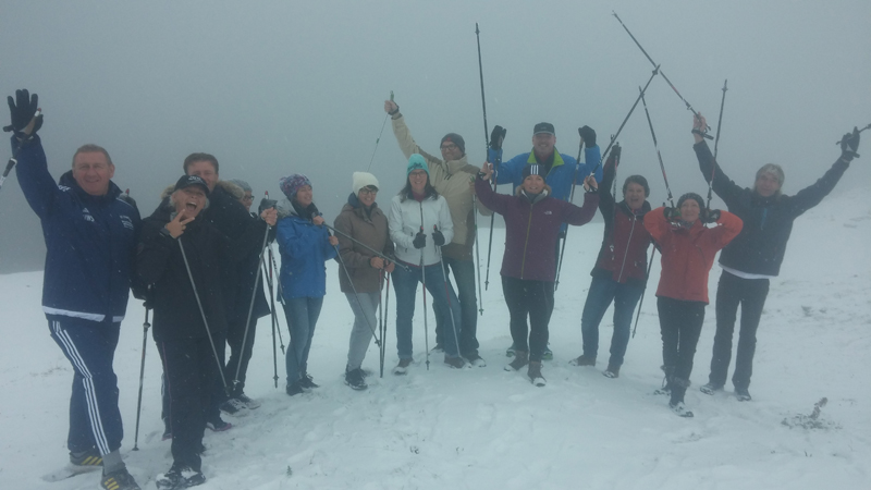 Jubelnde Nordic Walking Gruppe im Schneegestöber